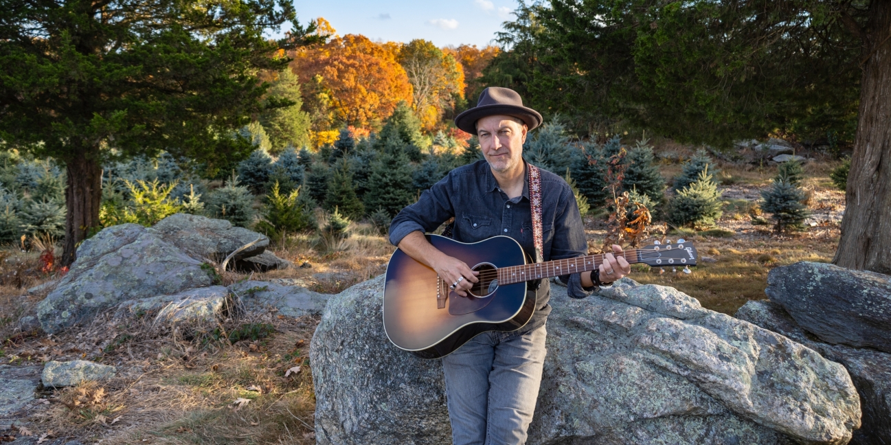 Brian Dolzani sitting on farm rocks in the fall