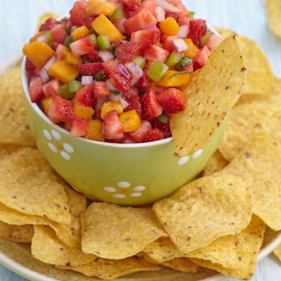 a bowl of Strawberry Salsa surrounded by corn chips