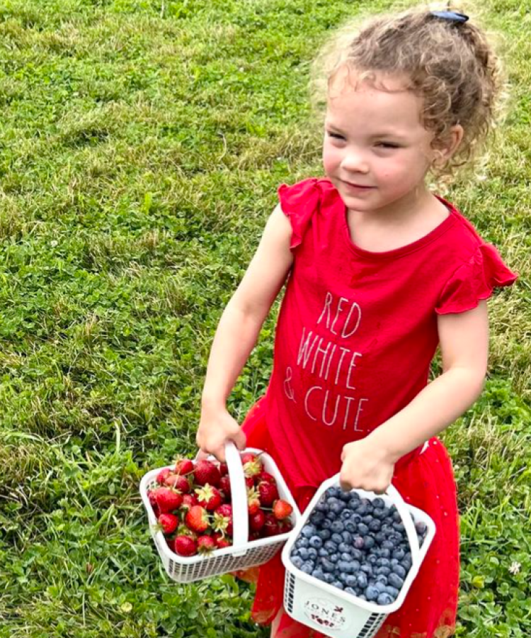 two cute kids holding strawberries and blueberries